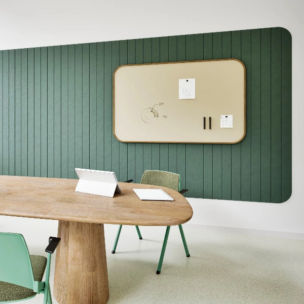 Grüne Chameleon Curve Wall Acoustics Akustikpaneele umrahmen ein beigefarbenes Whiteboard in einem modernen Besprechungsraum.